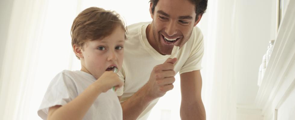 father and son brushing their teeth